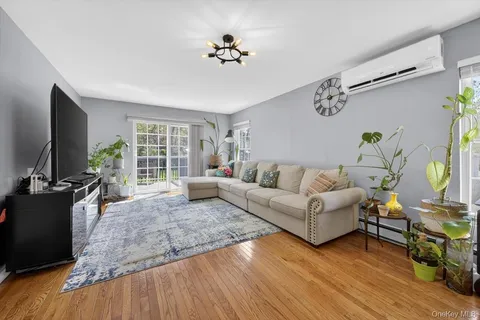 a living room with furniture flat screen tv and a large window