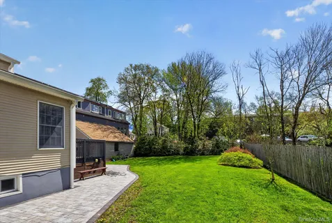 a view of a house with backyard and sitting area