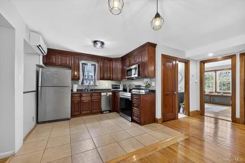 a kitchen with stainless steel appliances granite countertop a refrigerator a stove a sink dishwasher and a refrigerator with wooden floor