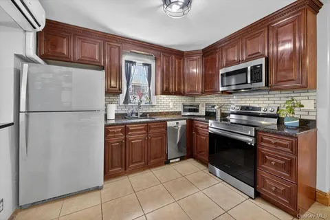 a kitchen with stainless steel appliances granite countertop a refrigerator stove a sink dishwasher and microwave
