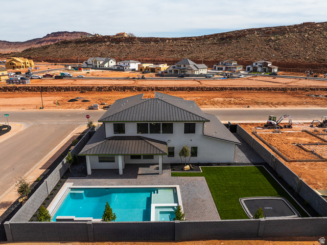 4658 South 380 East Washington, UT 84780 - Photo 5 of 10 Back of house with a fenced backyard, a mountain view, a patio area, a metal roof, and a pool with connected hot tub
