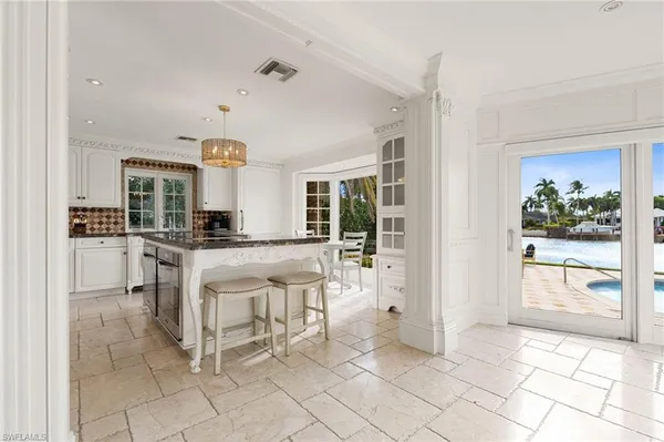 a kitchen with granite countertop a table and chairs in it