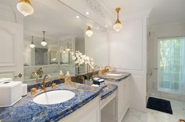 a bathroom with a tub a sink and a mirror
