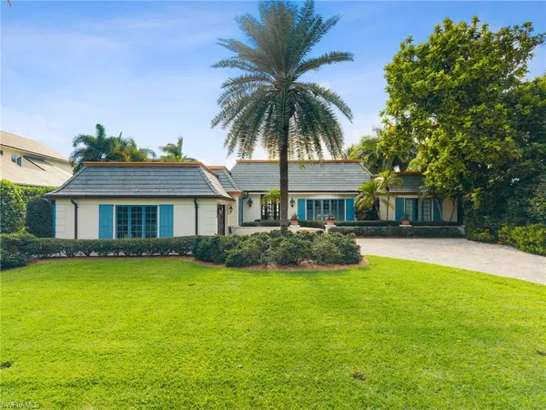 a front view of a house with yard and green space