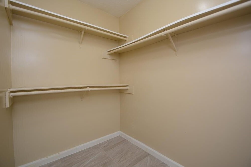 15 South Tallowberry Drive Spring, TX 77381 - Photo 20 of 26 Spacious walk-in closet with beige walls, shelves, and hanging rods providing ample storage.