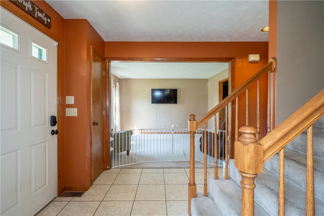 3628 Petre Road Springfield, OH 45502 - Photo 13 of 52 This inviting entryway features warm-toned walls, durable tile flooring, and a classic wooden staircase.