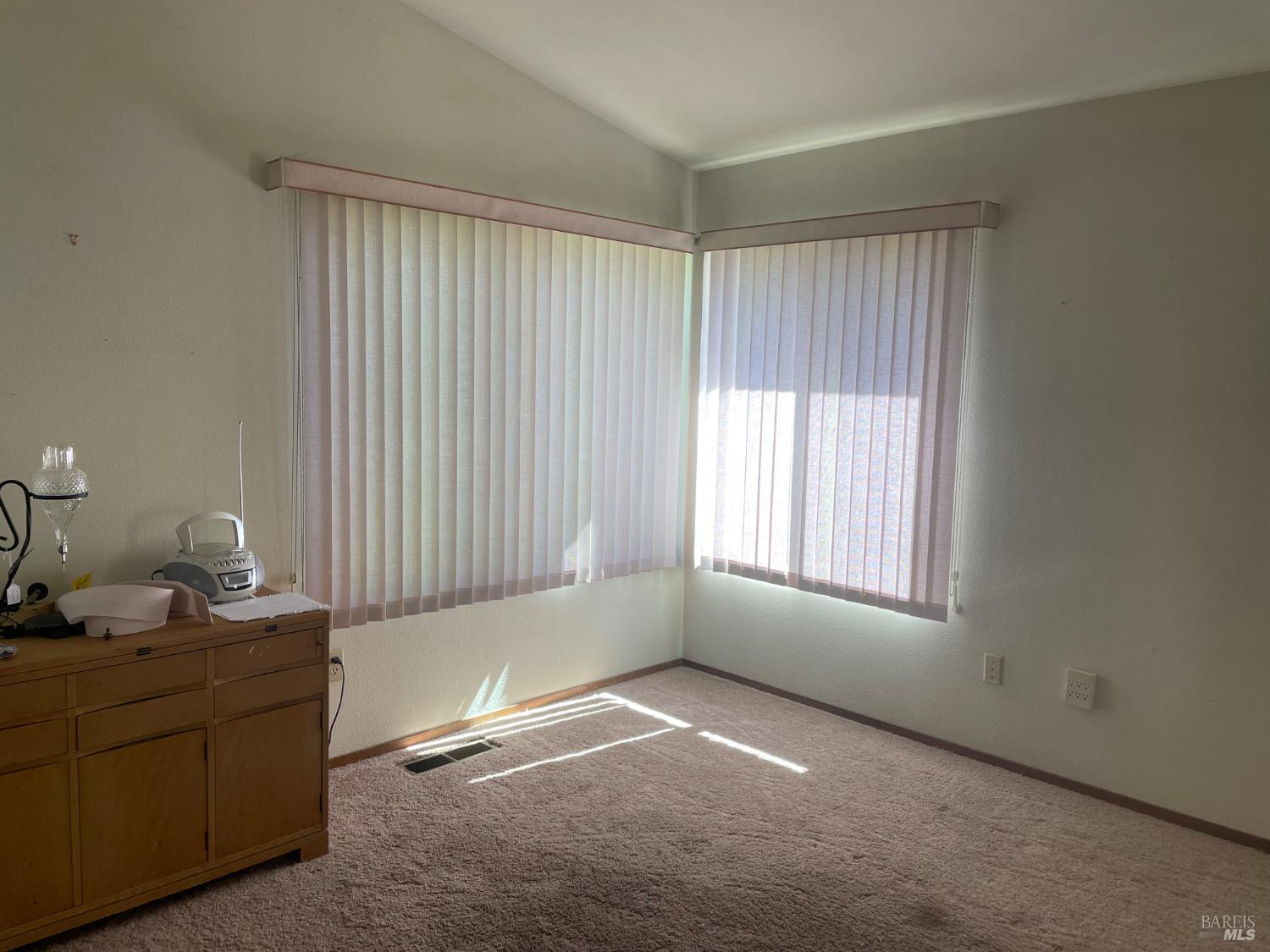 a room with a window and a dresser