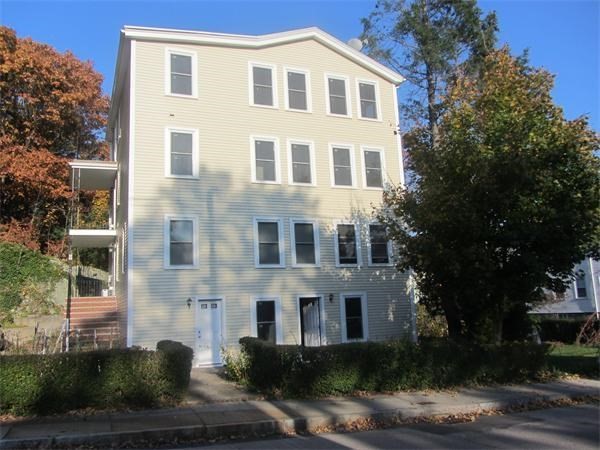 54 Desoto Road, Unit 3 Boston, MA 02132 - Photo 5 of 5 a front view of a building with a yard and trees
