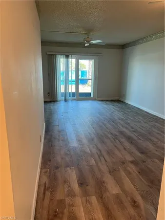 a view of a big room with wooden floor and windows