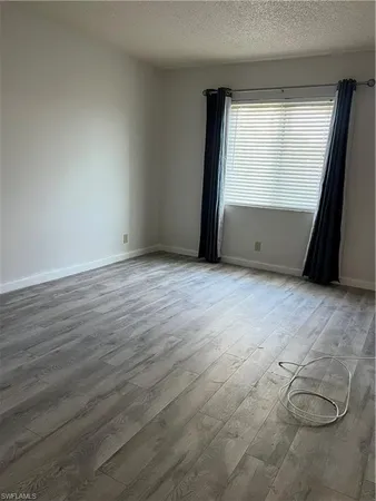 a view of a room with wooden floor and a window