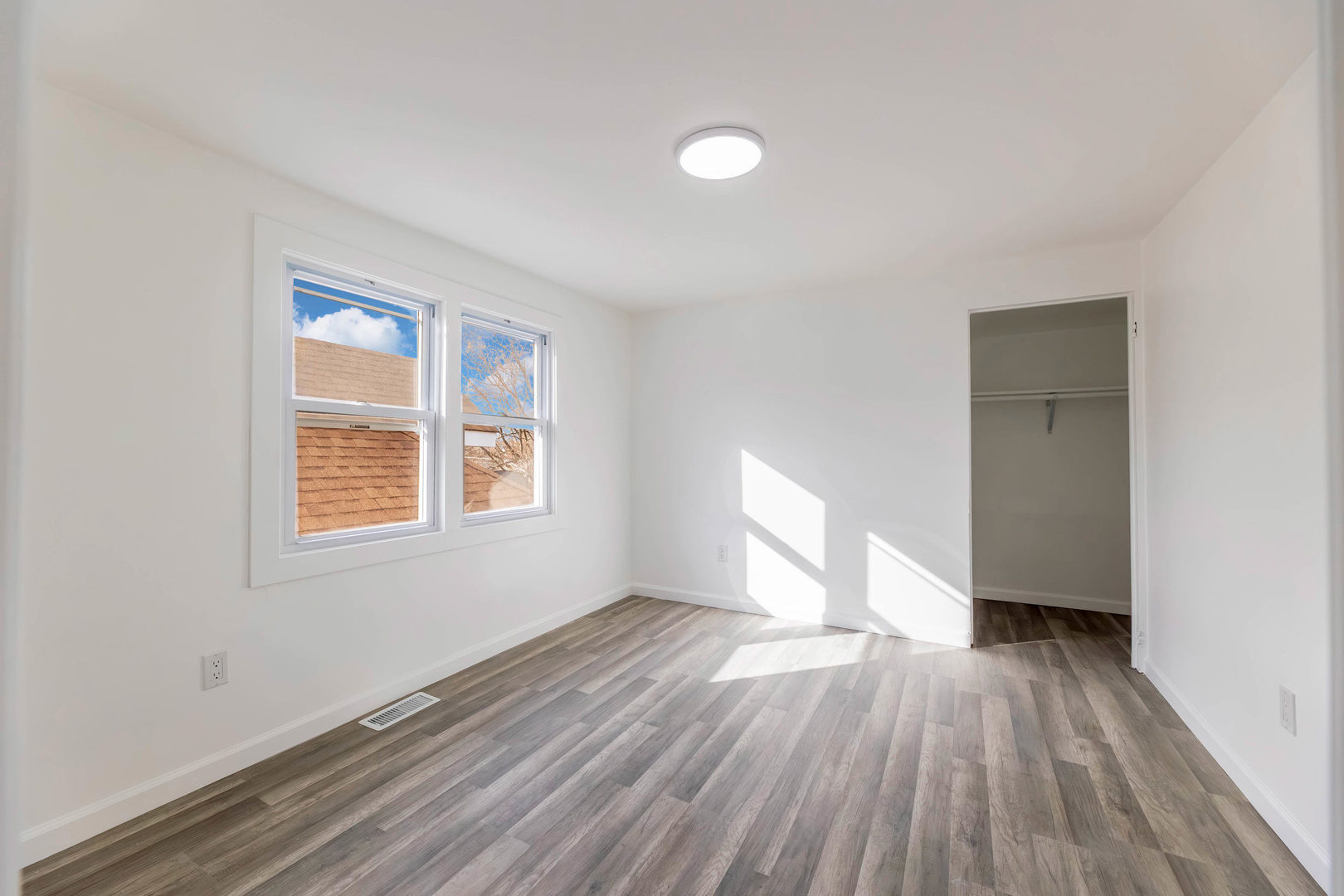 6742 South Carpenter Street Chicago, IL 60621 - Photo 18 of 36 an empty room with wooden floor and windows