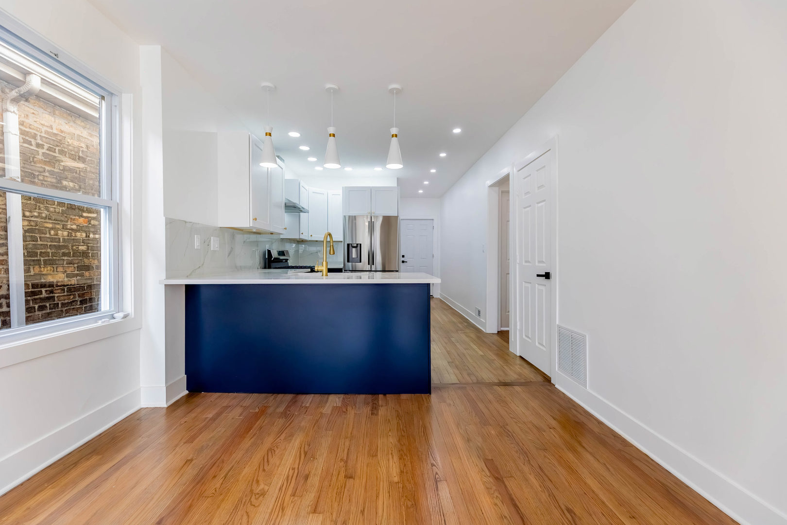 6742 South Carpenter Street Chicago, IL 60621 - Photo 6 of 36 a kitchen with stainless steel appliances kitchen island wooden floors and view living room