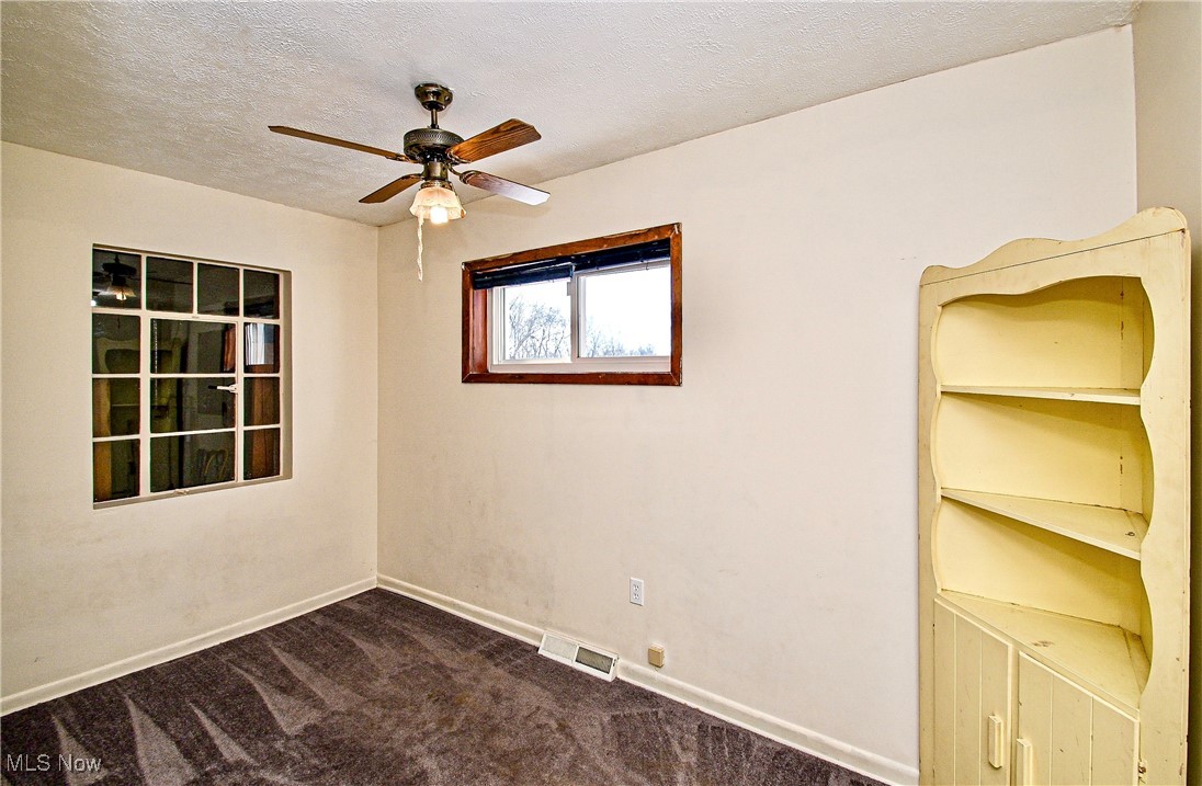 630 Neal Road Akron, OH 44312 - Photo 11 of 15 Bedroom with a textured ceiling, ceiling fan, and dark colored carpet