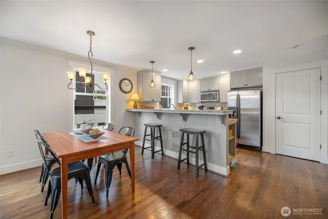 a view of a dining room and livingroom with furniture wooden floor a chandelier