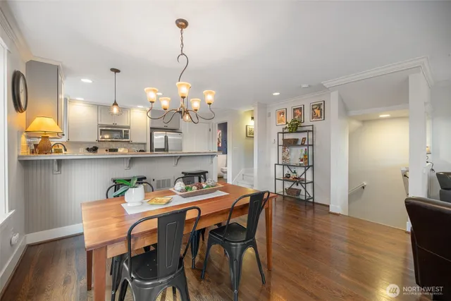 a dining room filled chandelier and wooden floor