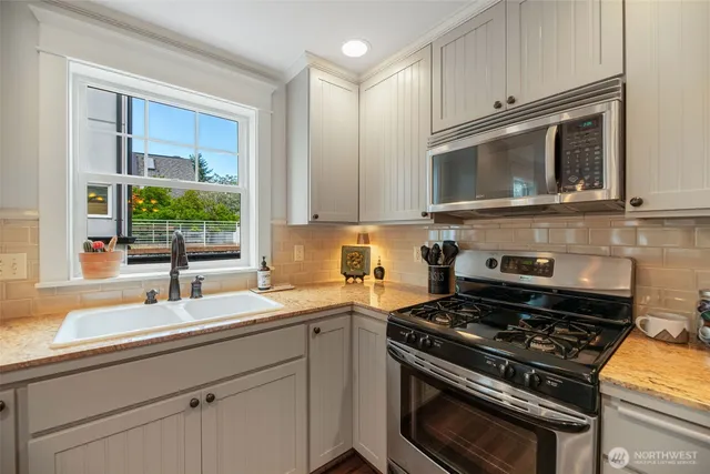 a kitchen with a stove a sink and a microwave