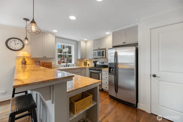 a kitchen with refrigerator cabinets and wooden floor