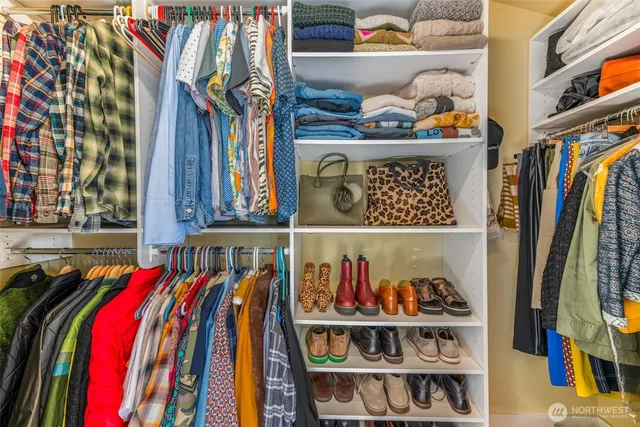 a view of walk in closet with clothes and shoes
