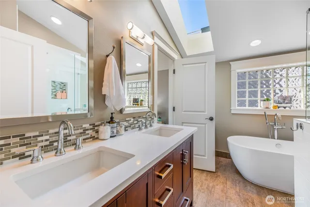 a bathroom with a tub a sink and a large mirror