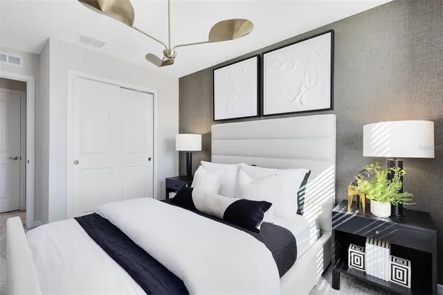 a bedroom with a bed and a lamp on the dresser