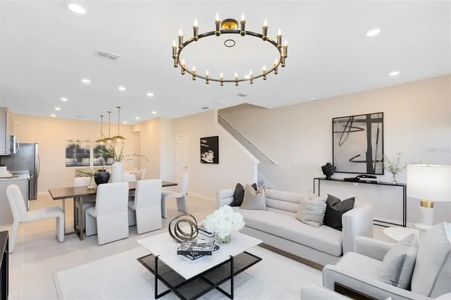 a living room with furniture a rug and kitchen view