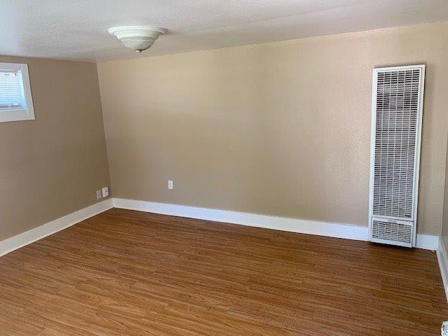 3014 Duke Street Lubbock, TX 79415 - Photo 3 of 10 a view of an empty room with wooden floor and a window