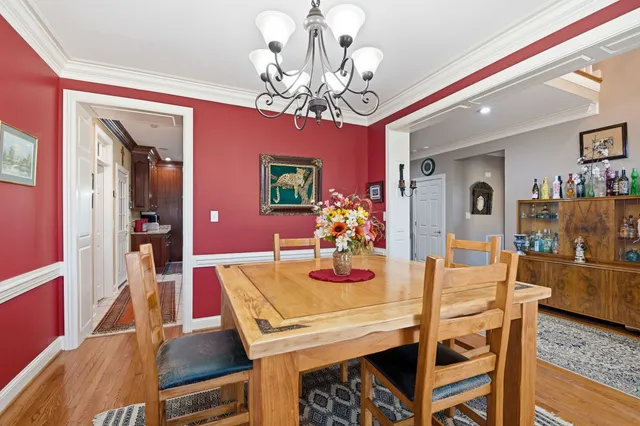 a view of a dining room with furniture a chandelier and wooden floor
