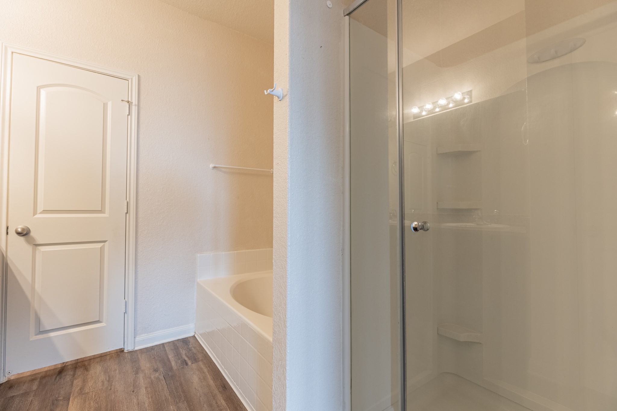 20017 Hubert R Humphrey Road Manor, TX 78653 - Photo 25 of 35 A well-maintained bathroom offers both a deep soaking tub and a clear glass-enclosed shower.