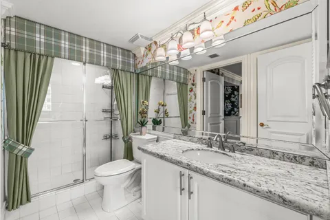 a bathroom with a granite countertop sink toilet and shower