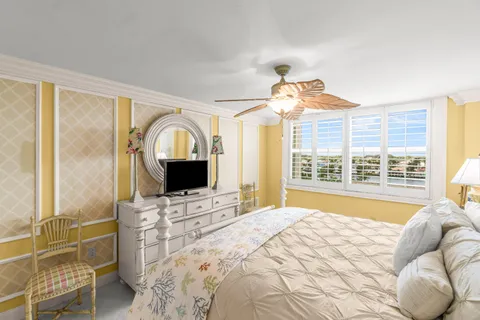 a bedroom with a bed a window and a chandelier