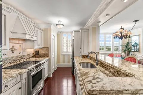 a kitchen with granite countertop a stove and a sink