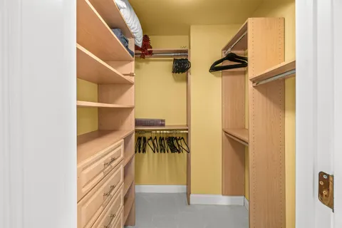 a view of walk in closet with clothes and shoes