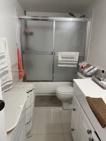a bathroom with a granite countertop sink mirror vanity and toilet