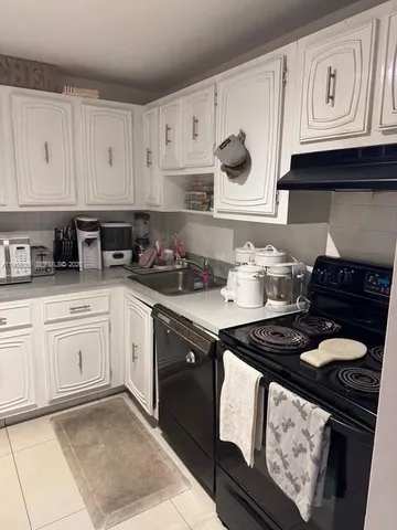 a kitchen with stainless steel appliances granite countertop white cabinets sink and stove