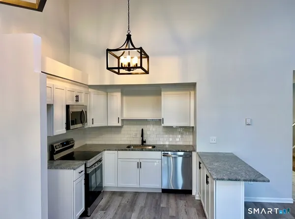 a kitchen with stainless steel appliances granite countertop a stove and cabinets