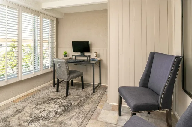 a view of a workspace with furniture and a window