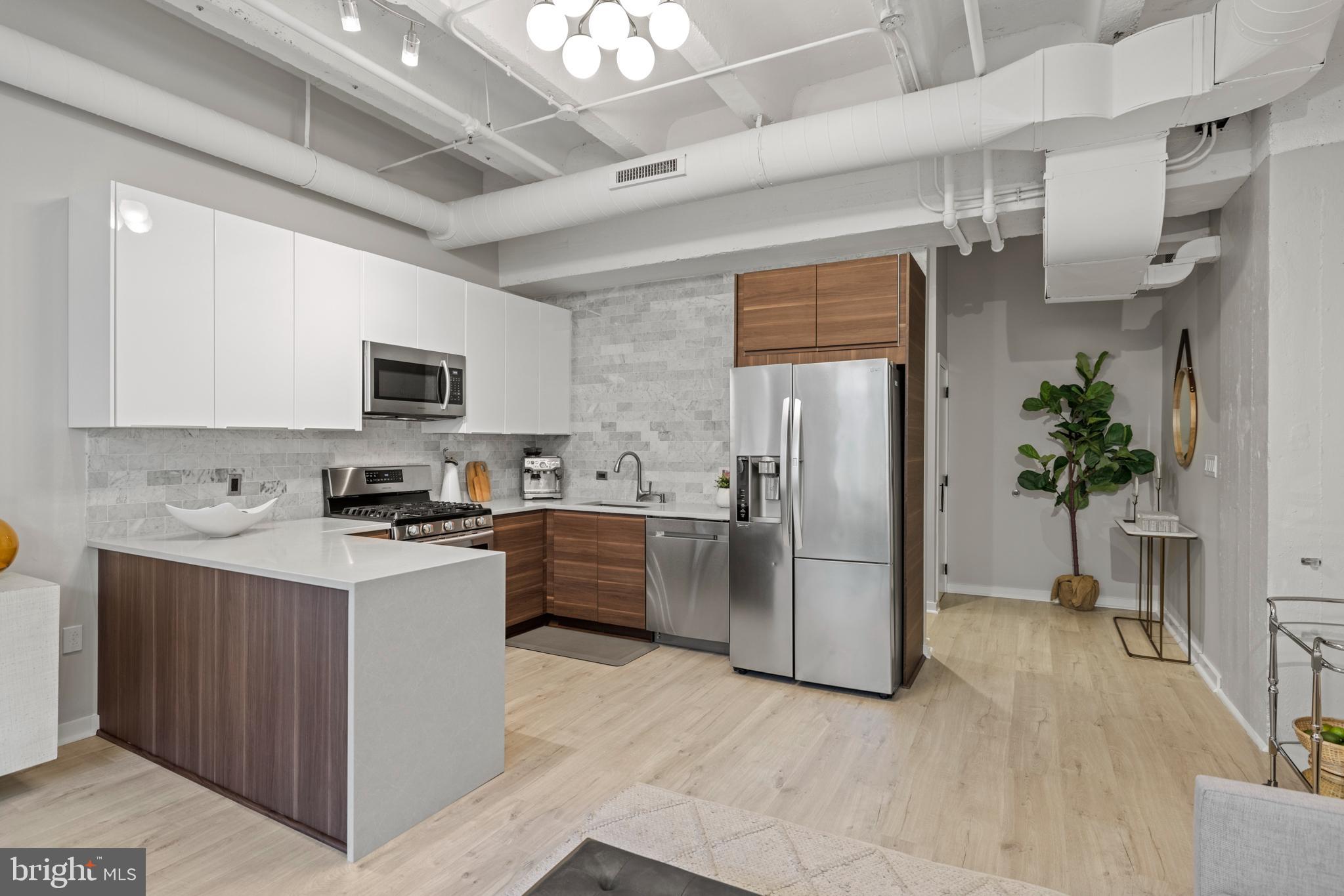 1401 Church Street Northwest, Unit 321 Washington, DC 20005 - Photo 7 of 33 a kitchen with stainless steel appliances a refrigerator a sink a stove top oven a counter space and cabinets