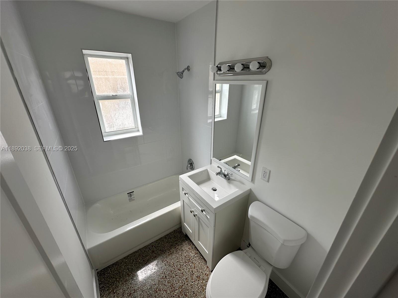 211 Southwest 18th Avenue, Unit 2 Miami, FL 33135 - Photo 10 of 14 a bathroom with a toilet sink and mirror next to a window