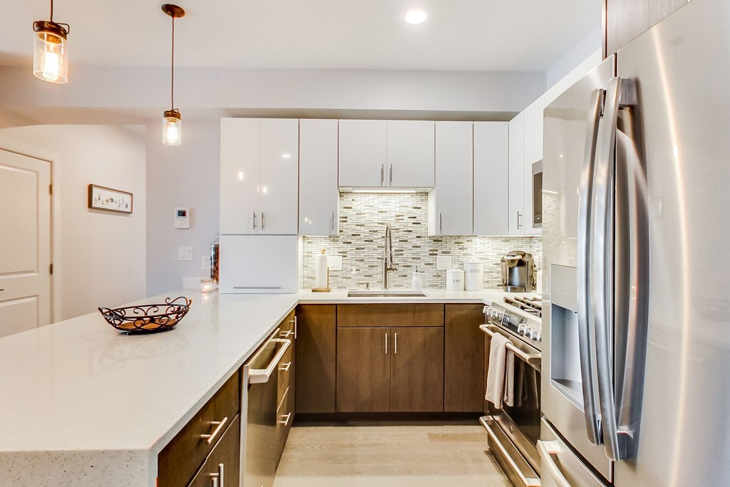 a kitchen with stainless steel appliances granite countertop a sink refrigerator and cabinets