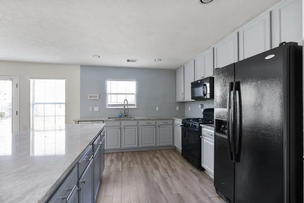 a open kitchen with granite countertop a sink and dishwasher with wooden floor