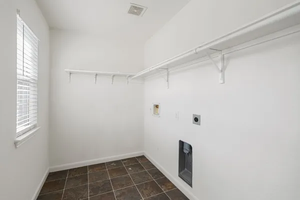an empty room with wooden floor a ceiling fan and windows