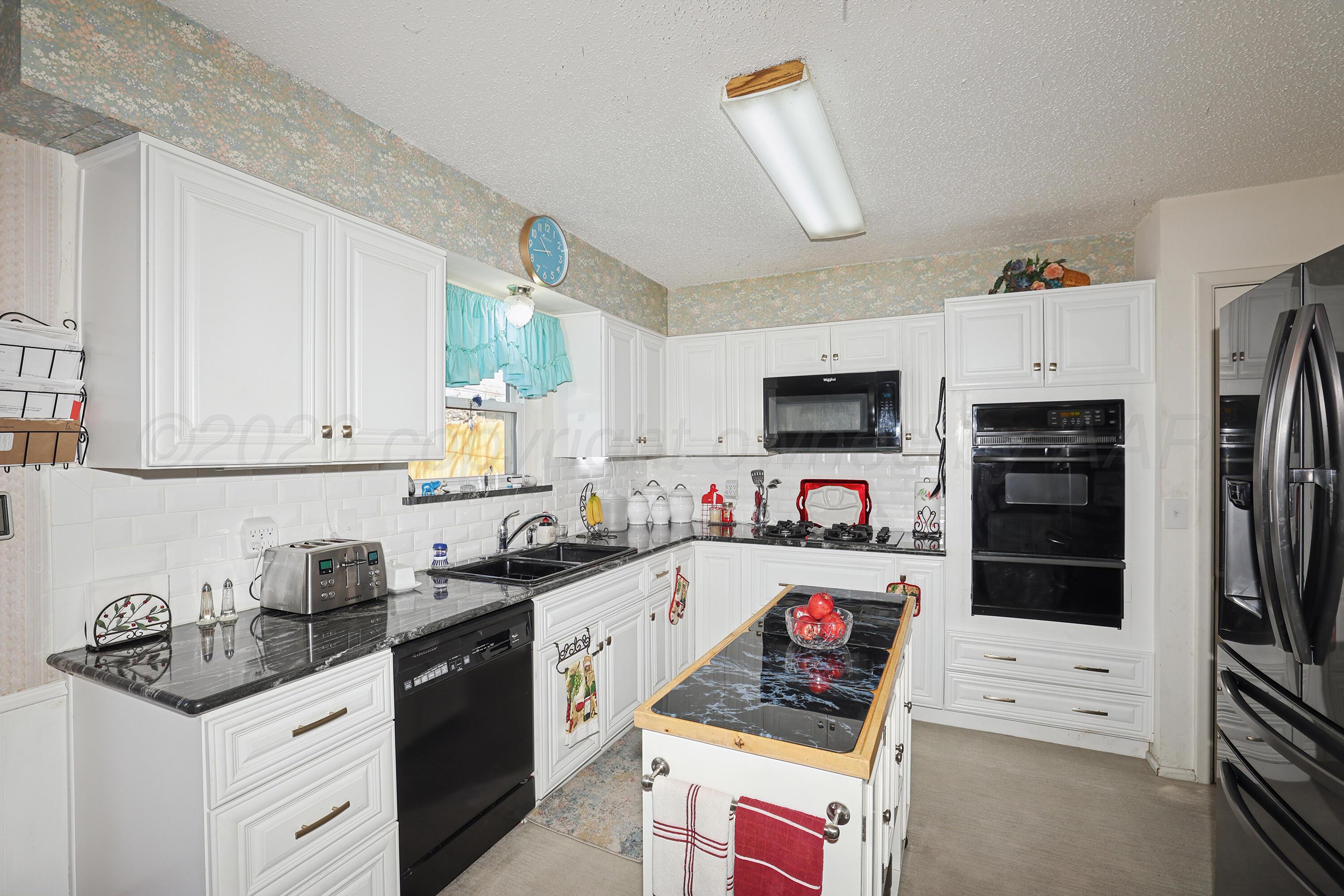 3708 Wayne Street Amarillo, TX 79109 - Photo 13 of 36 a kitchen with stainless steel appliances granite countertop a refrigerator and a stove top oven