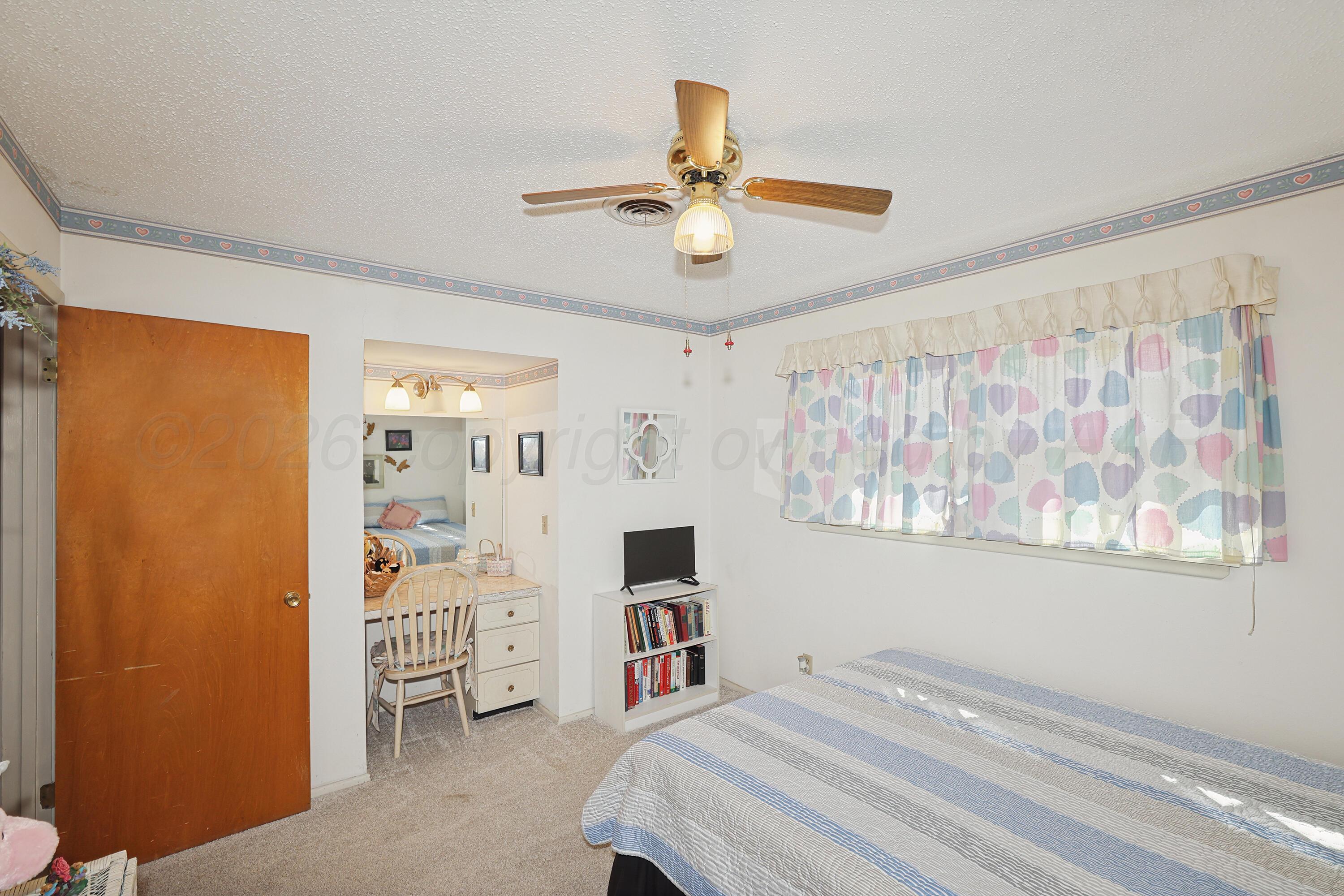 3708 Wayne Street Amarillo, TX 79109 - Photo 21 of 36 a bedroom with a bed and a chandelier