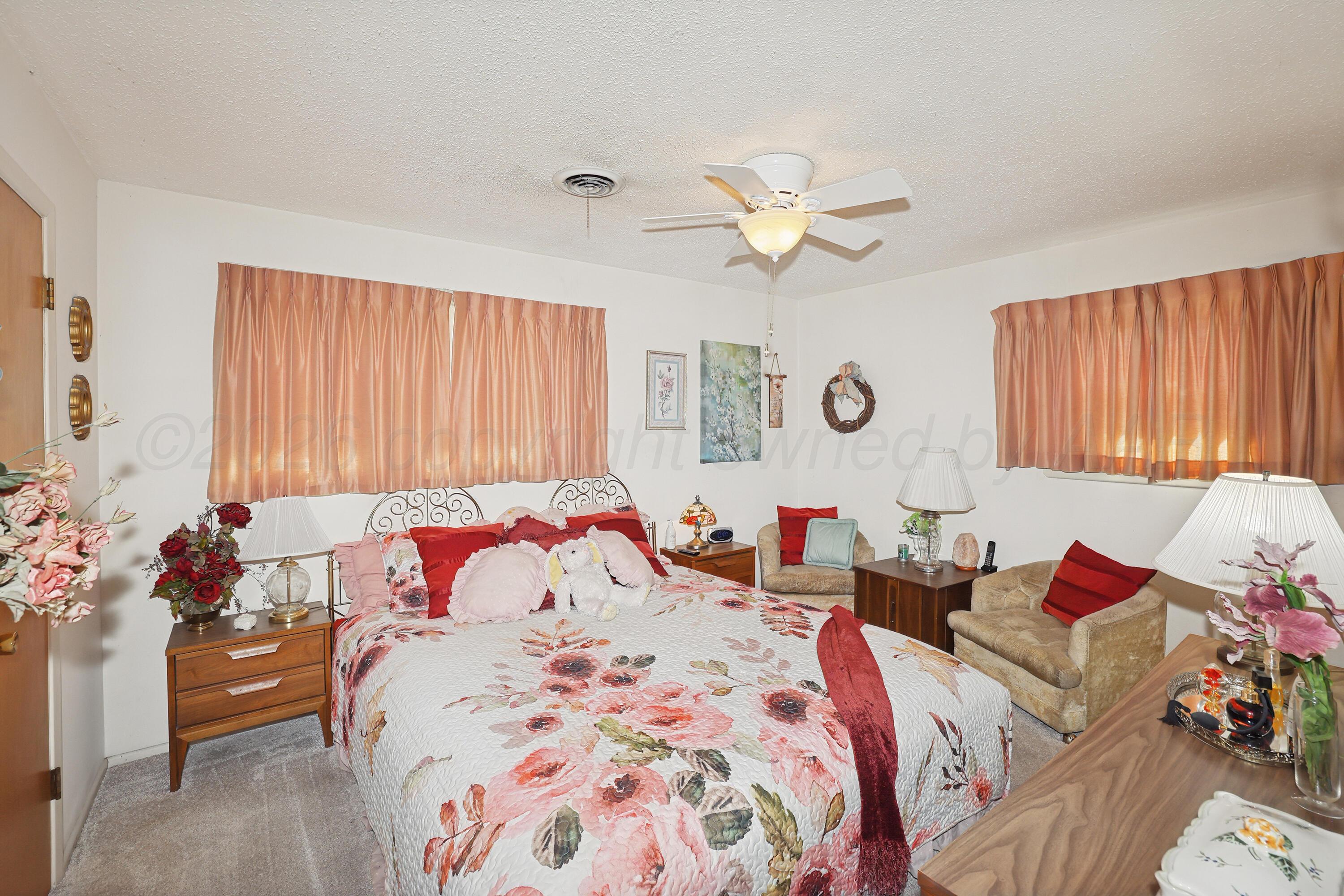 3708 Wayne Street Amarillo, TX 79109 - Photo 22 of 36 a bedroom with a bed and a chandelier