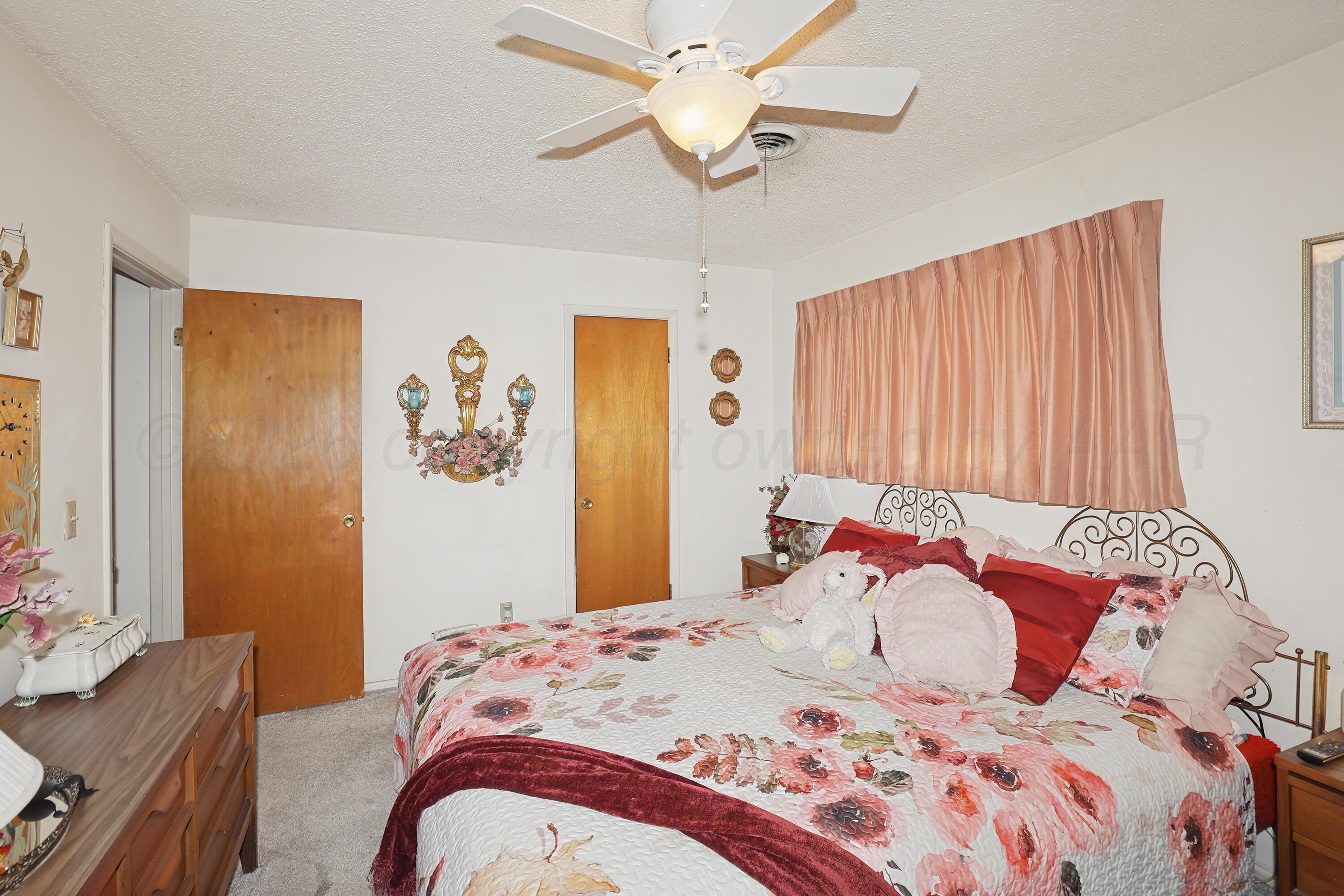 3708 Wayne Street Amarillo, TX 79109 - Photo 24 of 36 a bedroom with a bed and a chandelier