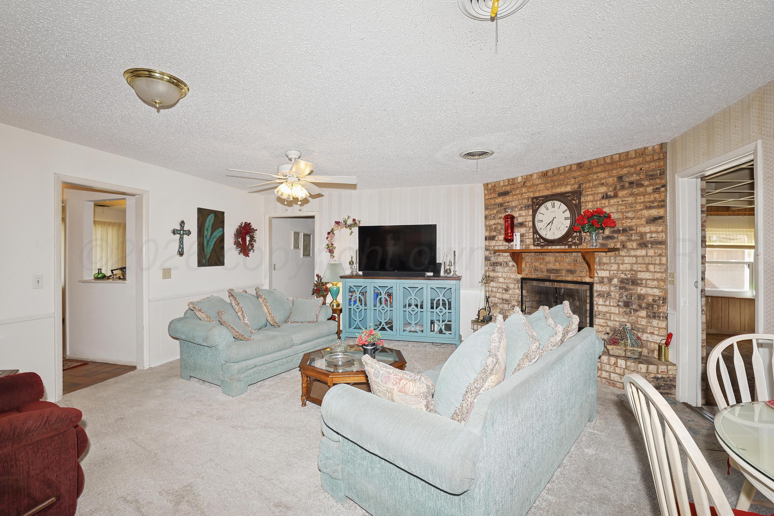 3708 Wayne Street Amarillo, TX 79109 - Photo 9 of 36 a living room with furniture a flat screen tv and a fireplace