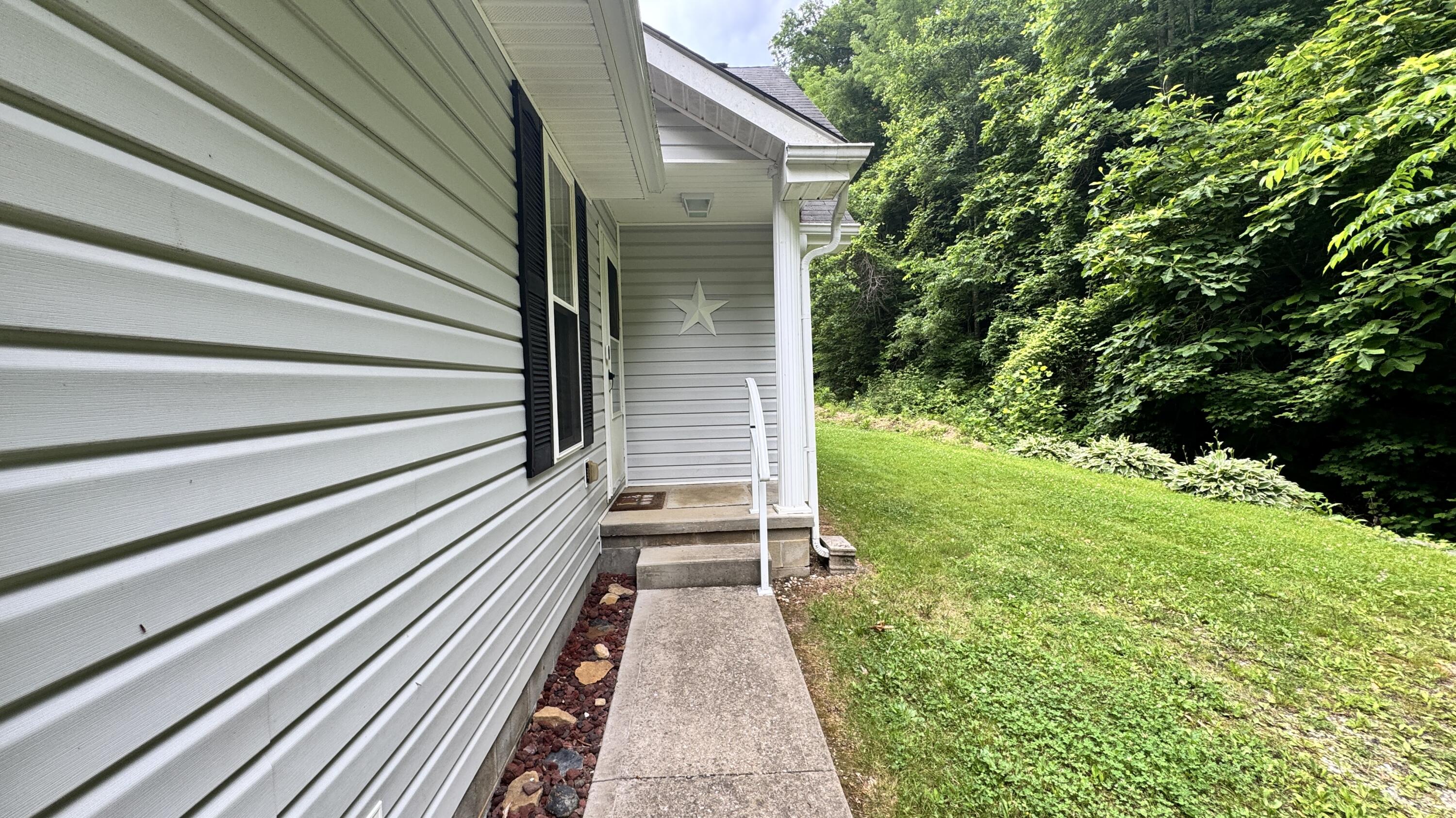 421 Wren Br Road Oneida, KY 40972 - Photo 19 of 34 concrete sidewalk from garage to house.