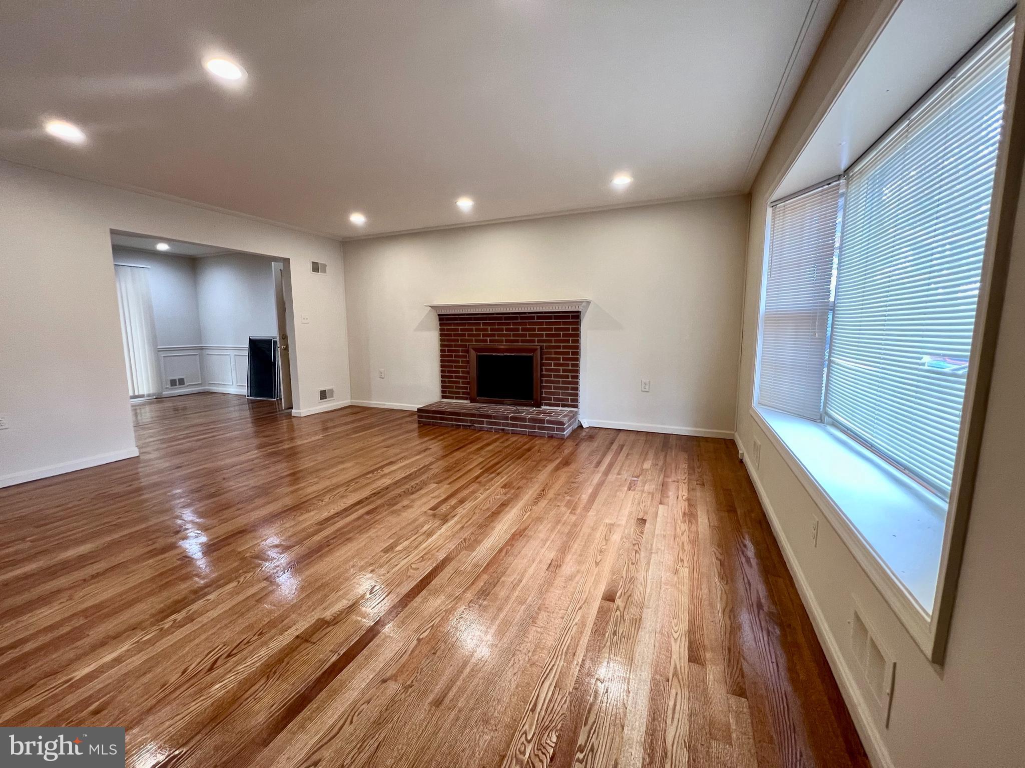 7510 Sanner Road Laurel, MD 20723 - Photo 6 of 26 wooden floor in an empty room with a fireplace