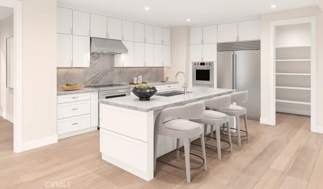 a kitchen with a sink a stove a refrigerator and white cabinets