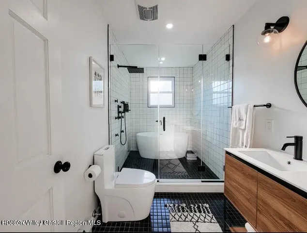 a bathroom with a sink toilet a mirror and shower